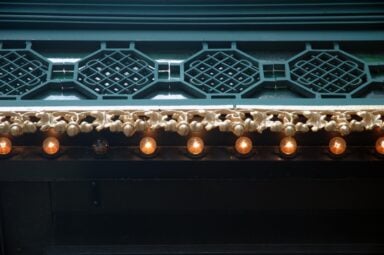A close-up view of an elegant light fixture, with one bulb extinguished, symbolizing burnout symptoms.